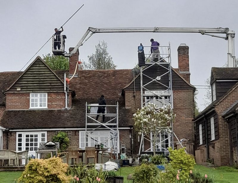 The Roof Moss Cleaners using cherry picker and scaffolding to clean roof safely and professionally in Hindhead, Surrey